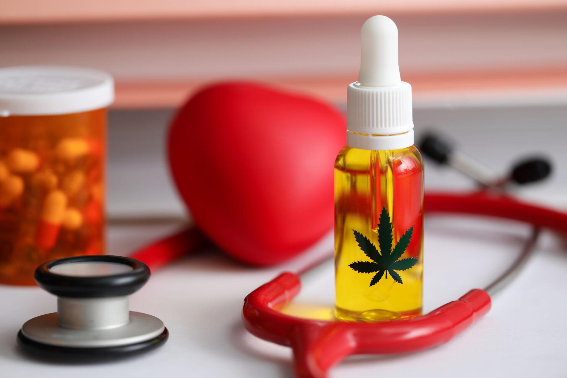 Medical cannabis oil, capsules and a stethoscope on table.