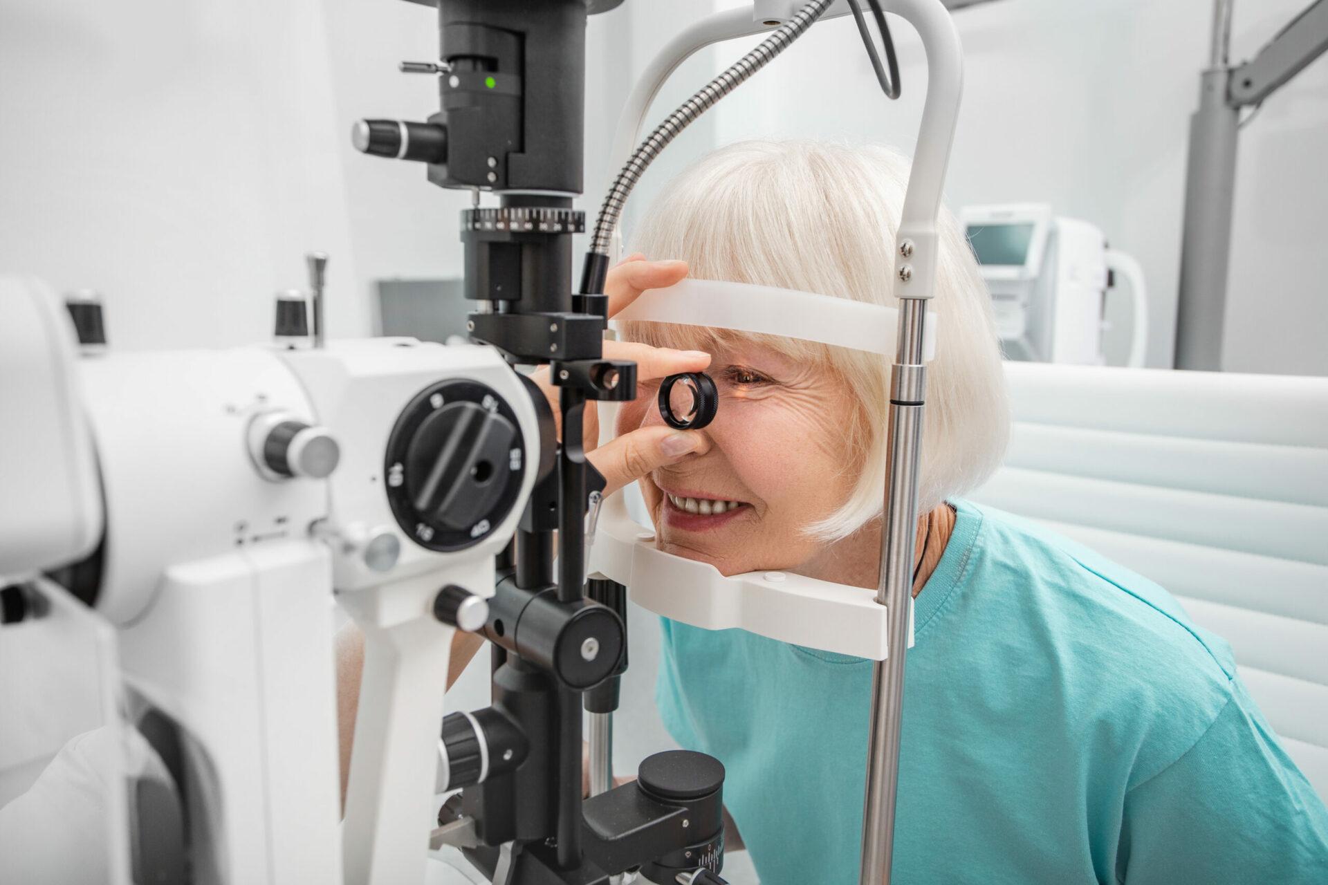 Elderly woman eyesight test with binocular slit-lamp