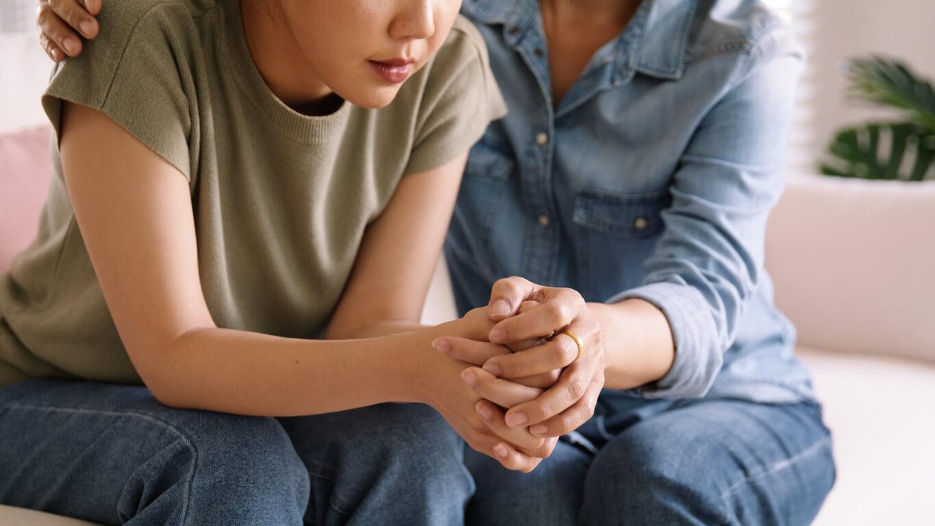 Two individuals, one appearing to be comforting the other