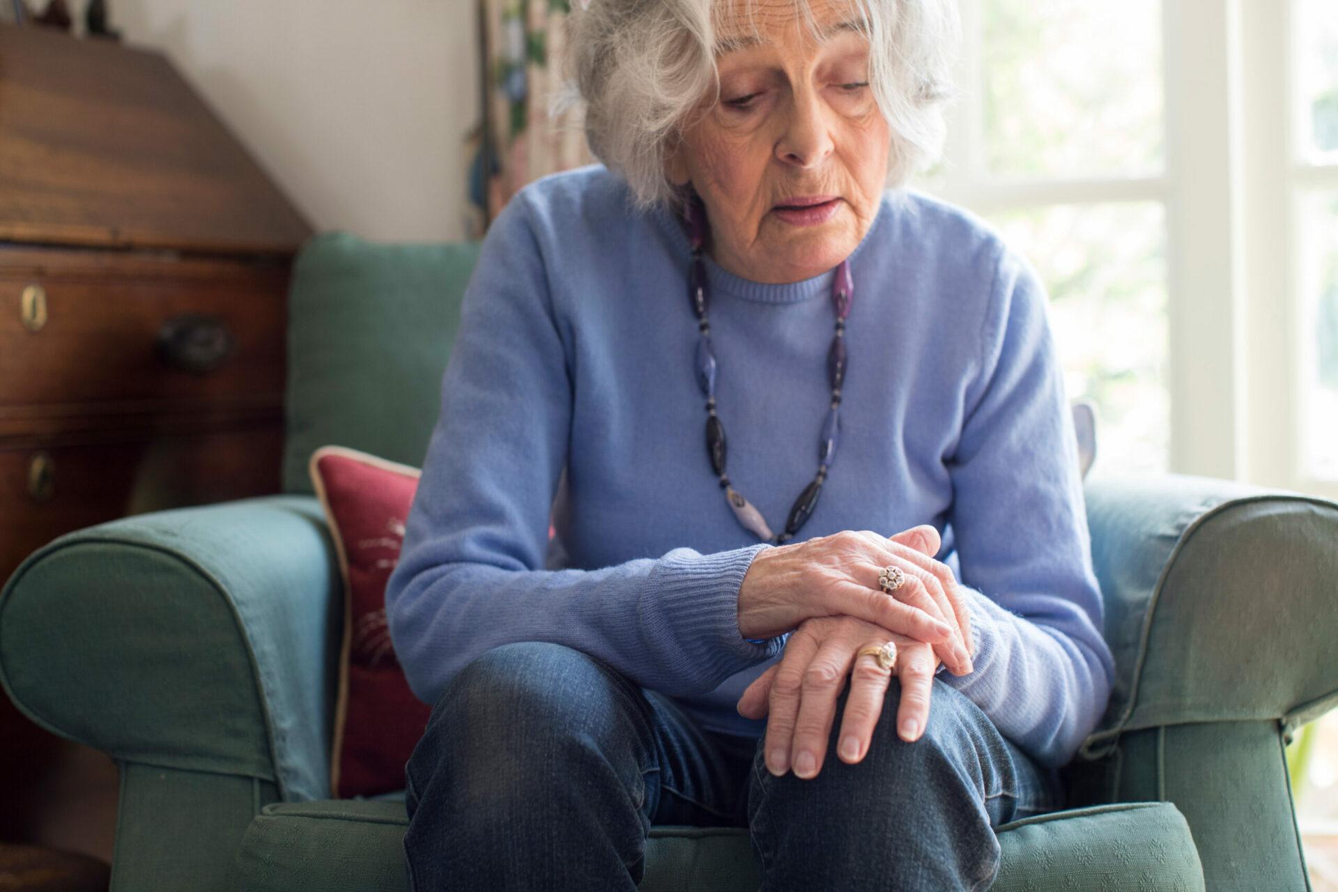 enior woman With Parkinson's disease holding hand in pain 