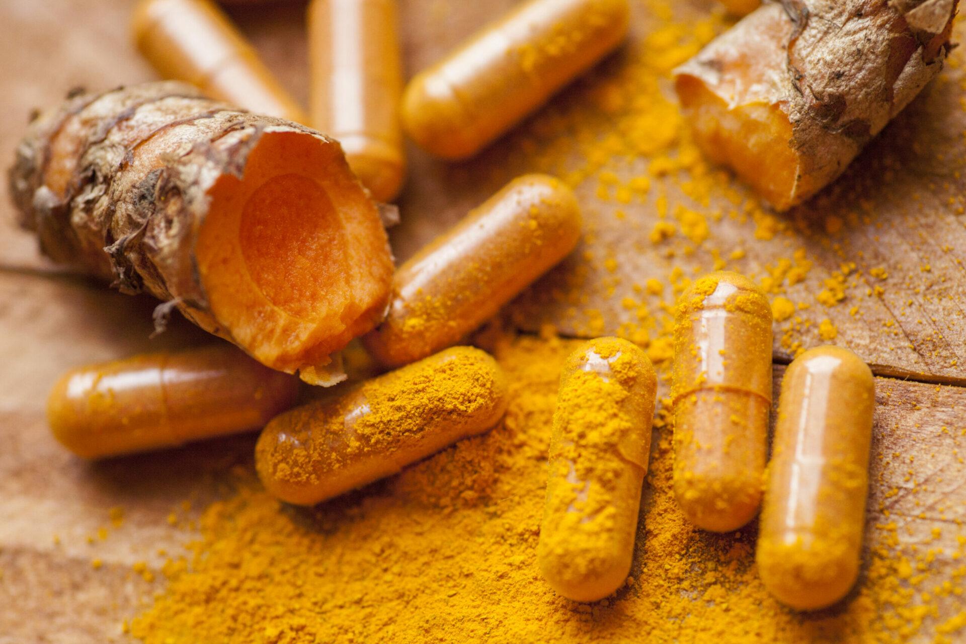 Raw organic turmeric root with powder and medicine herbal vitamin supplement pill capsules
