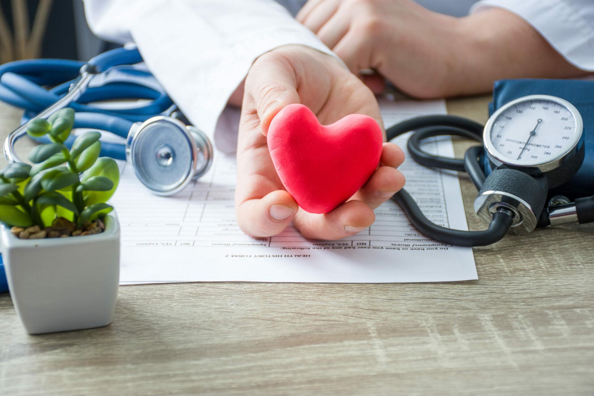 Doctor holding in his hands a figure of red card heart