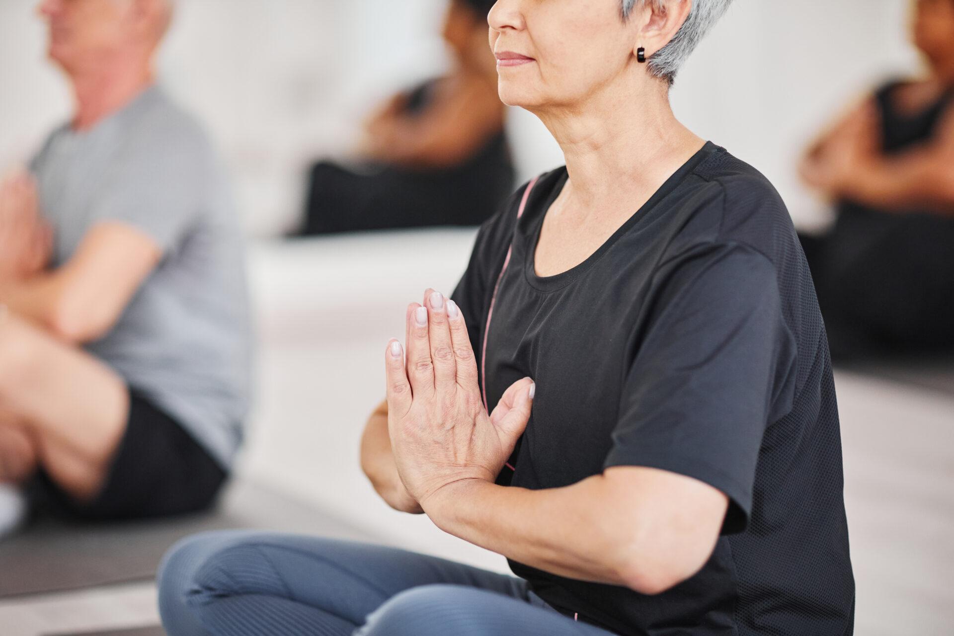 Senior woman meditating during yoga training.