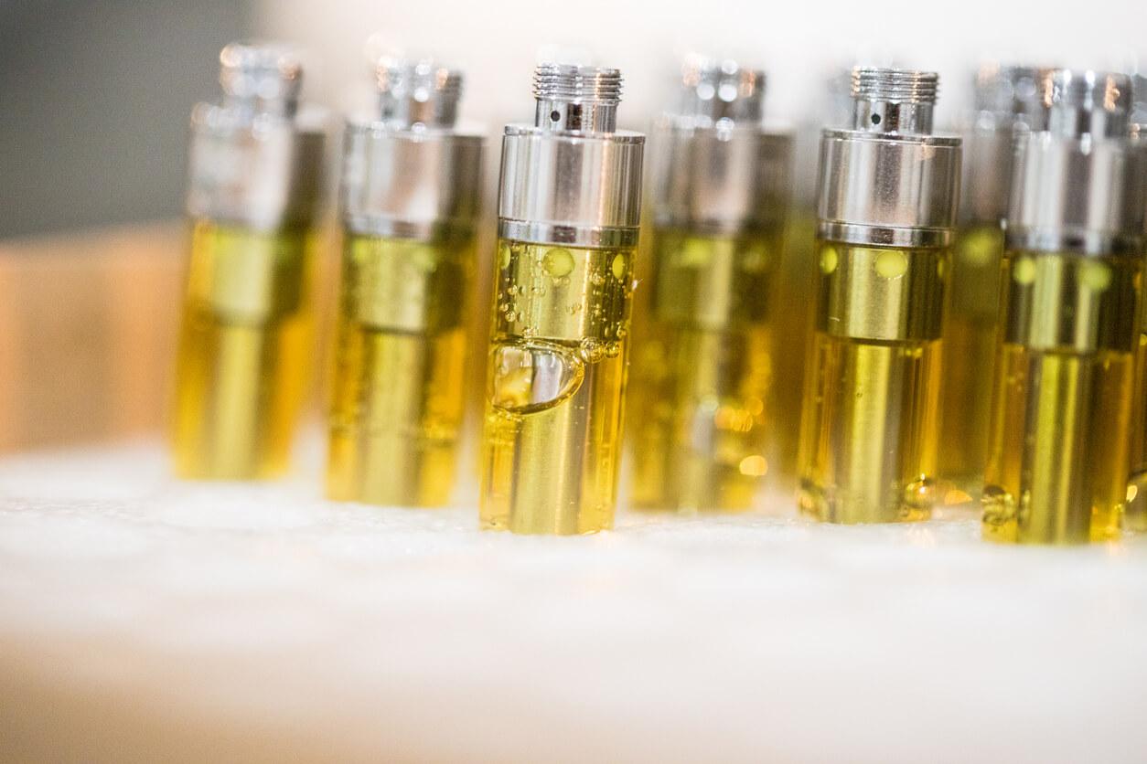 Close-up of several vape cartridges filled with yellow liquid, standing upright in rows. 
